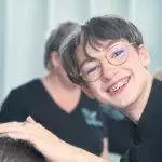 Jeune étudiant en coiffure souriant et dynamique en TP