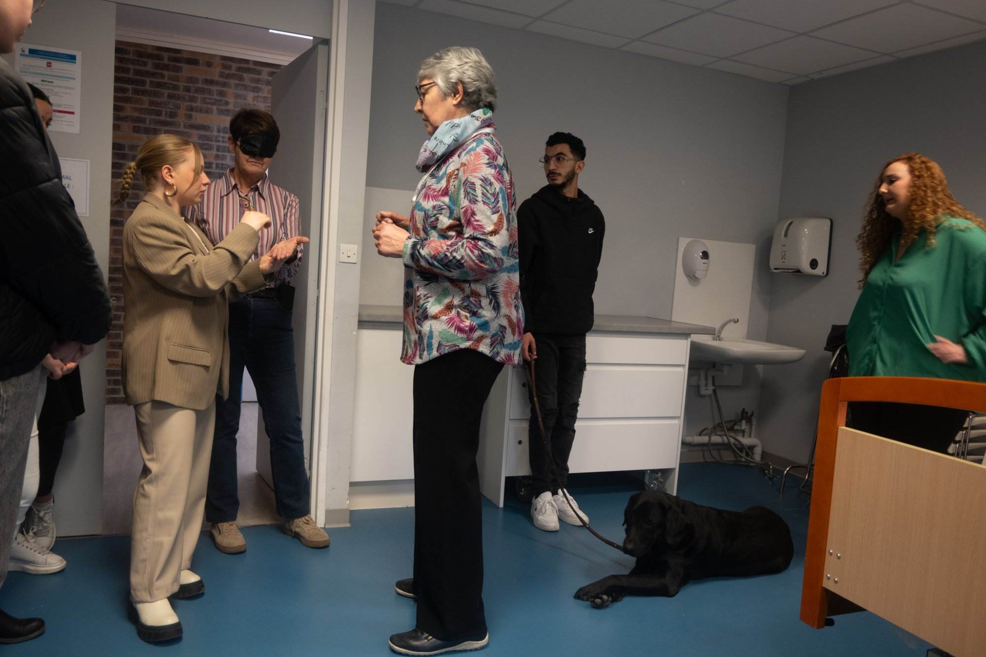 TP - Personnes discutant avec un chien-guide assis.
